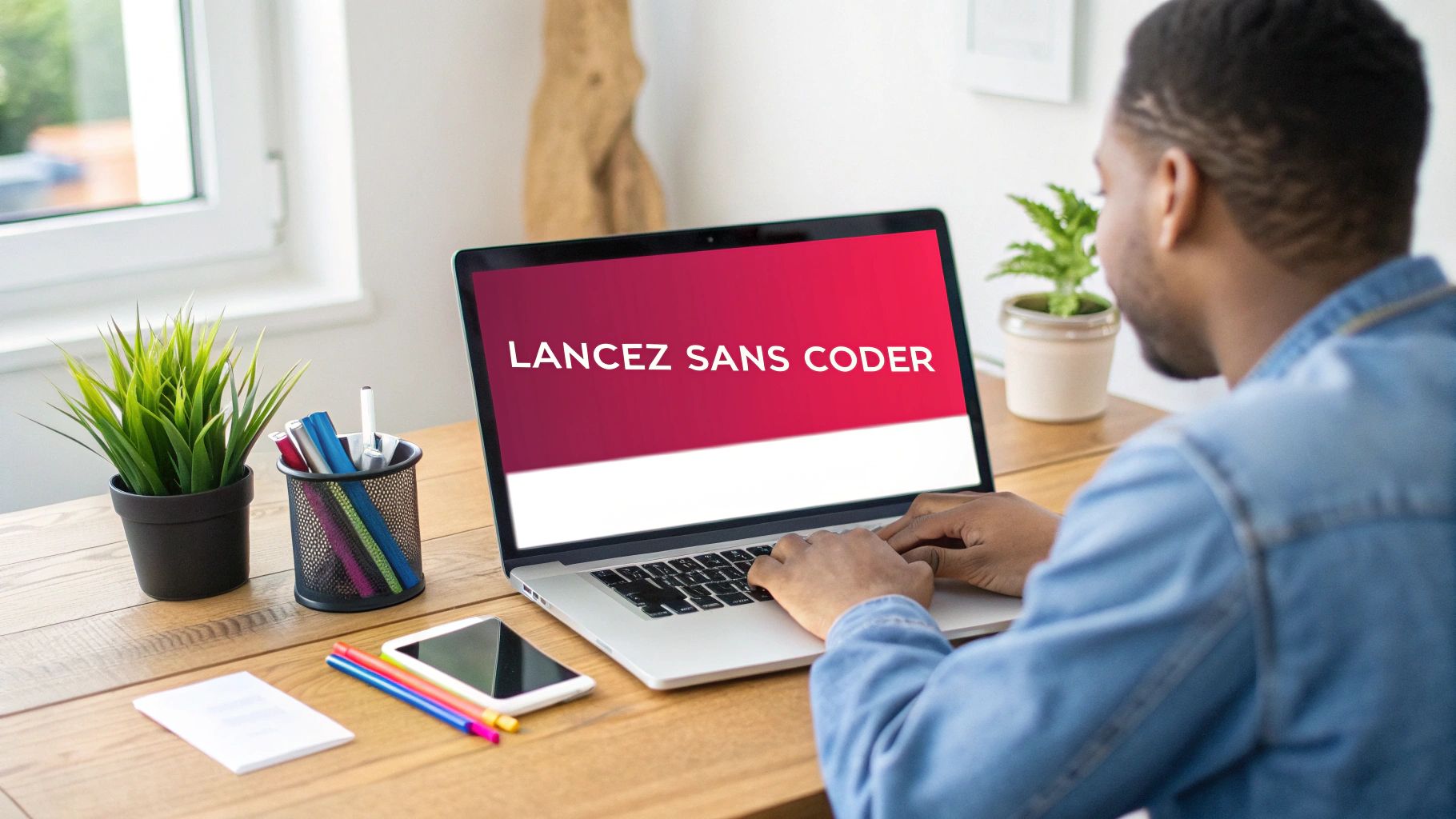 Un homme travaille sur un ordinateur portable affichant "LANCEZ SANS CODER" dans un bureau à domicile.