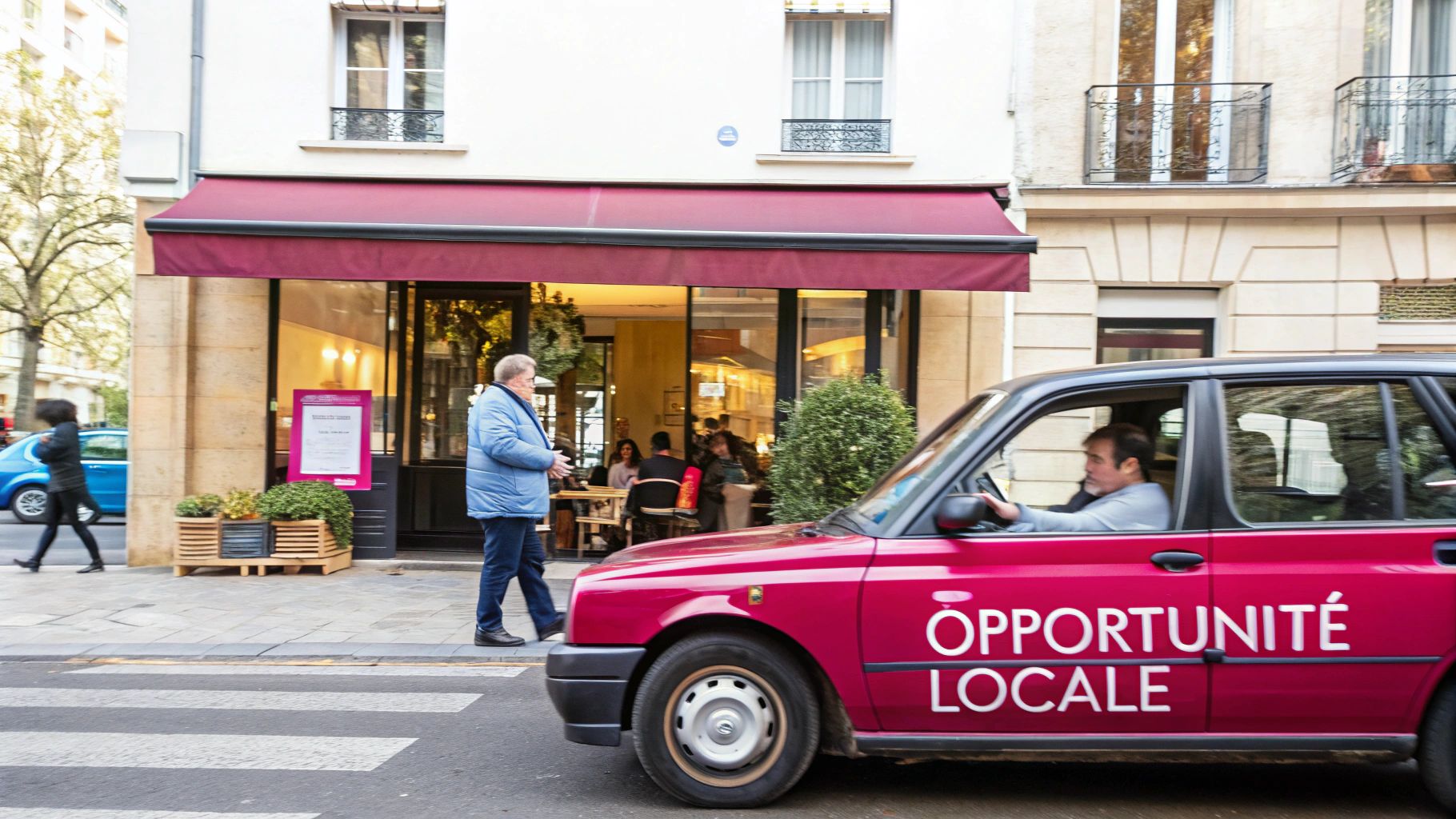 Une voiture rose avec l'inscription "OPPORTUNITÉ LOCALE" passe devant un café animé et des piétons en ville.